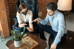 Two adults collaborate using a smartphone inside a modern office setting.