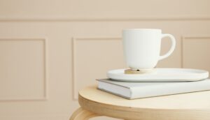 A white ceramic mug on a tray, placed over a closed book on a wooden table.