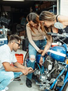 A family working together to repair a motorcycle in their garage.
